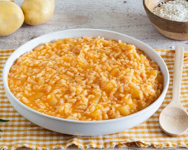 Un cremoso risotto con patate, arricchito da pepe nero e rosmarino fresco. Ingredienti semplici per un piatto confortante.