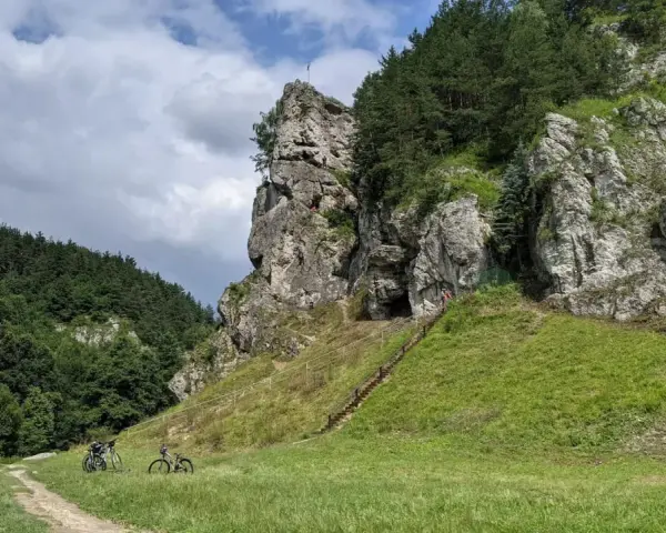Dolina Kobylańska zachwyca skalnymi formacjami i zielonymi zboczami. Na ścieżce rowerzyści, a na skałach wspinacze.