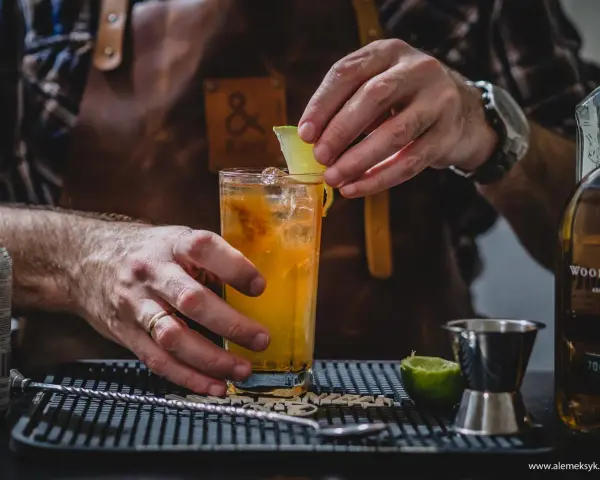 Barman kończy przygotowywać drinka na tequili, dodając plasterek limonki.