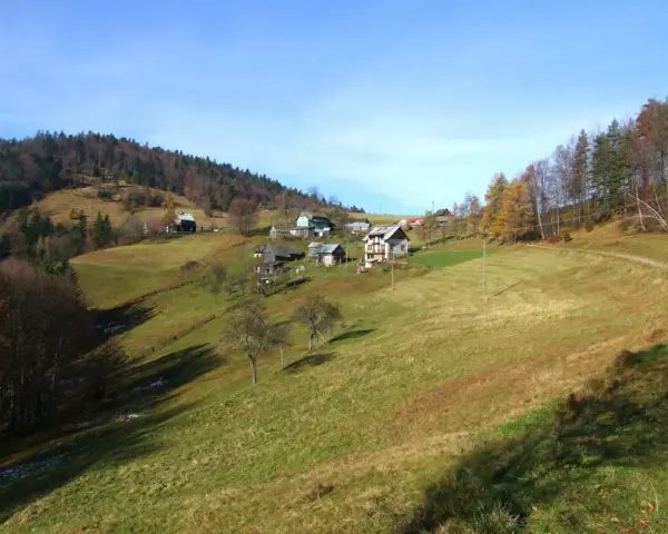 Jesienne krajobrazy Krynica Zdrój szczyty. Domy na zboczach, lasy i łąki.