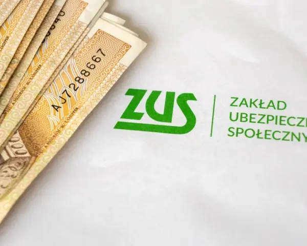 Pieniądze i logo ZUS. Symbolizuje to świadczenie rehabilitacyjne, które można uzyskać dzięki ubezpieczeniu społecznemu.