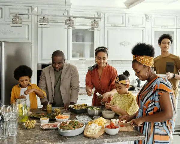 Une famille prépare un repas ensemble, partageant des moments précieux. Les ingrédients sont disposés sur le comptoir, comme un trésor **réduit aux acquets** de leur amour.