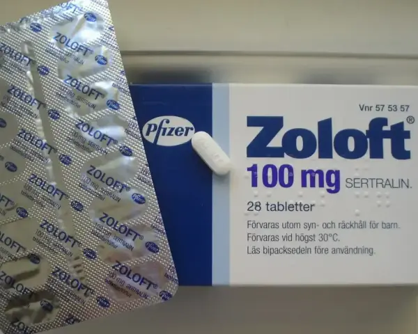 Opakowanie leku Zoloft 100 mg z sertraliną i pojedyncza tabletka. Lek ten pomaga w leczeniu depresji.
