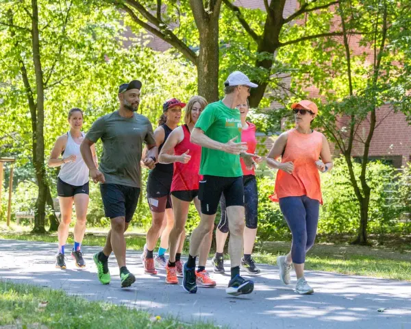 Eine Gruppe von Läufern genießt eine gemeinsame Trainingseinheit in Berlin. Die Laufgruppen Berlin sind aktiv und motiviert.