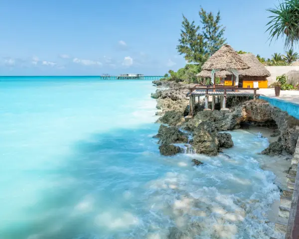 Turkusowe morze i tropikalna zabudowa na skale. Idealne miejsce na relaks, a zanzibar ceny mogą być zaskakująco przystępne.