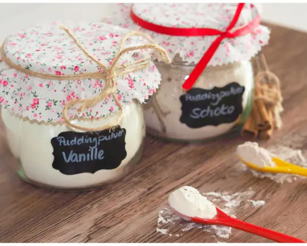 Zwei Gläser mit selbstgemachtem Vanillepuddingpulver und Schokopulver, liebevoll verziert. Perfekt zum vanillepuddingpulver selber machen.