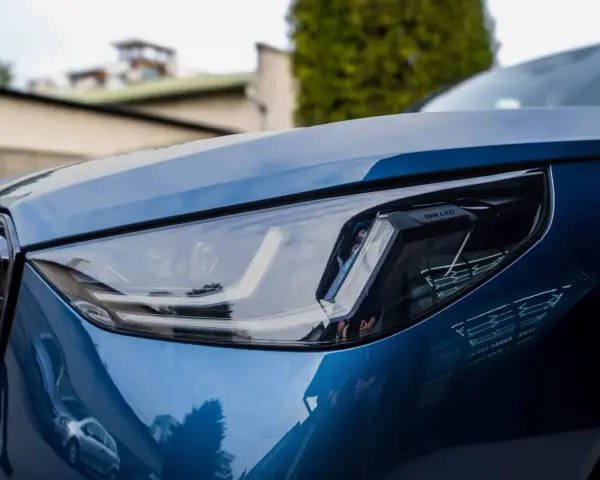 Błyszczący, niebieski lakier BMW z reflektorem LED. To właśnie autodetailing co to znaczy, że samochód wygląda jak nowy.