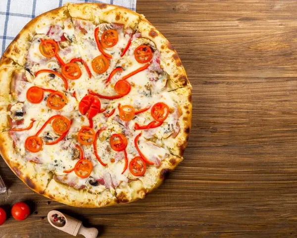 Apetyczna pizza z pomidorkami i papryką, idealna na wieczór. Czy zastanawiałeś się nad pizza hut kalorie?