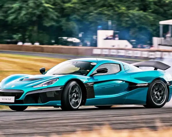 Niebieski Rimac Nevera, najszybsze auto elektryczne, driftuje na torze, wzbijając tumany dymu.