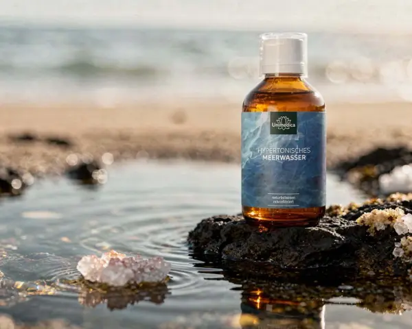 Bouteille d'eau de Quinton sur un rocher, évoquant le bien-être des intestins et la pureté de l'océan.
