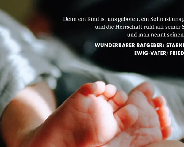 Zarte Füße eines Neugeborenen, umgeben von weichen Stoffen. Der Text zitiert Jesaja 9,5: "Wunderbarer Ratgeber, starker Gott, Ewig-Vater, Friedefürst.