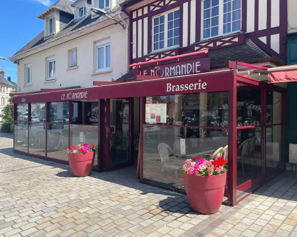 Brasserie Le Normandie, un lieu idéal pour déguster un bon pont l'évêque, fromage au goût unique. Fleurs colorées devant.