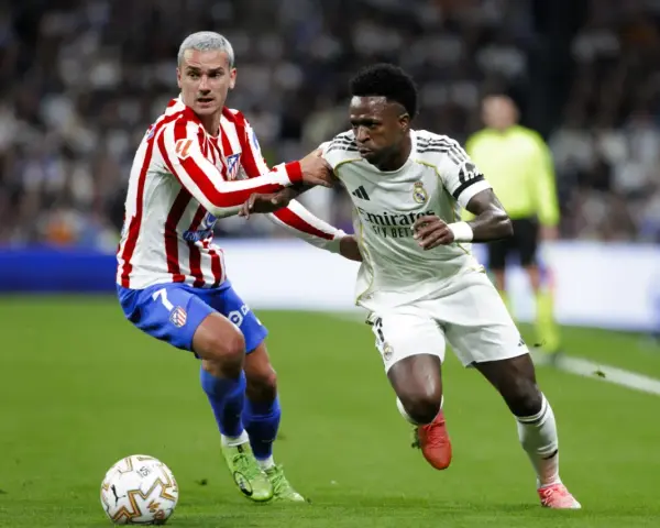 Griezmann z Atletico Madryt walczy o piłkę z Viniciusem z Realu Madryt. Dwa kluby z Madrytu w akcji.