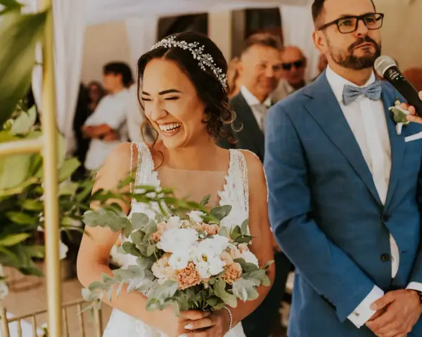 Szczęśliwa panna młoda z bukietem kwiatów podczas ceremonii. Ile trwa ślub cywilny? Krótka, wzruszająca chwila.