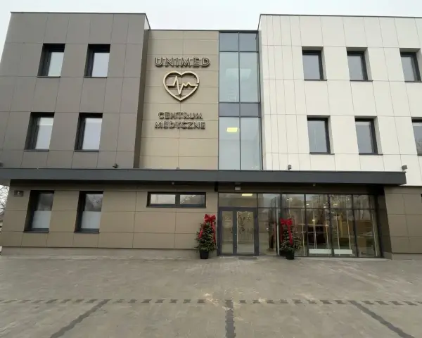 Nowoczesny budynek centrum medycznego Unimed z logo serca i pulsu.