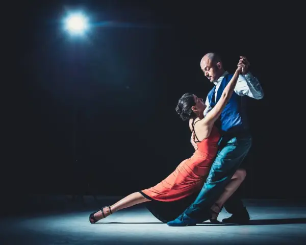 Para, w czerwonej sukni i mężczyzna w kamizelce, tańczą tango. "Taniec to krótki cytat o tańcu.