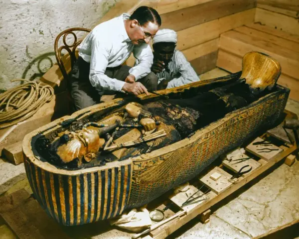 La photo découverte tombeau Toutankhamon : des archéologues examinent la momie dans son sarcophage orné.