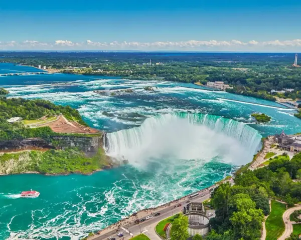 Potężne wodospady Niagara w pełnej krasie, gdzie jest niagara, z turkusową wodą i zielonymi brzegami.