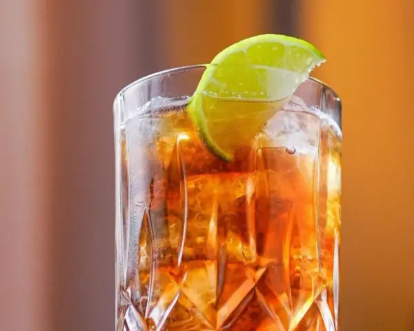 Orzeźwiający Long Island drink z lodem i plasterkiem limonki, idealny na letnie wieczory.