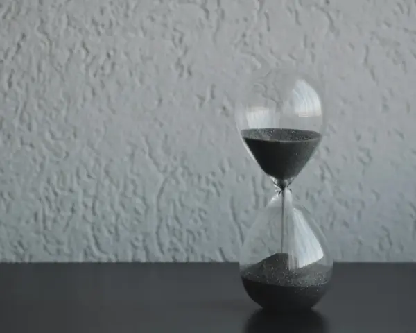 Clessidra con sabbia nera che scorre, simbolo del tempo che passa. Quanto tempo portare il lutto? Il tempo guarisce, ma il ricordo resta.