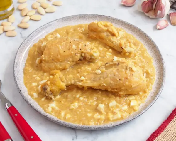 Pollo en pepitoria, un plato tradicional con trozos de pollo en una salsa cremosa de almendras y huevo duro.