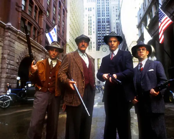 Quatre hommes en costume et chapeau, armés, se tiennent dans une rue de Chicago. Une scène tirée de "Les Incorruptibles, histoire vraie".