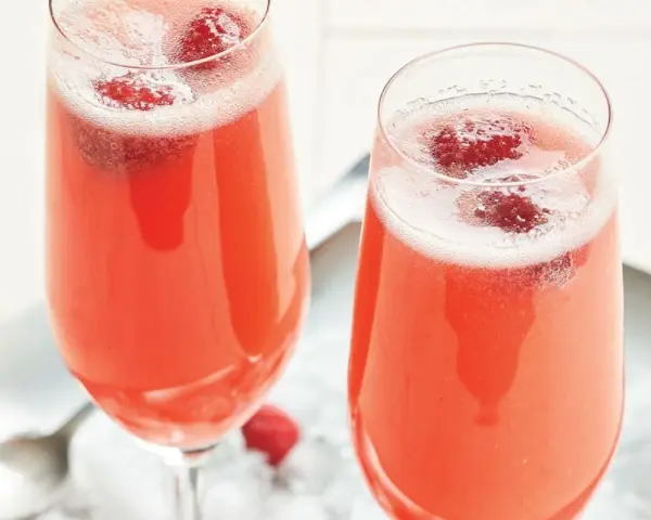 Två glas med ett rosa drink med bubbel och hallon. Perfekt för en festlig stund.