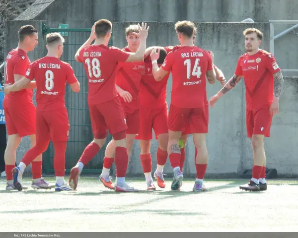 Piłkarze RKS Lechia świętują, jeden z nich, Jakub Biernat, cieszy się z sukcesu.