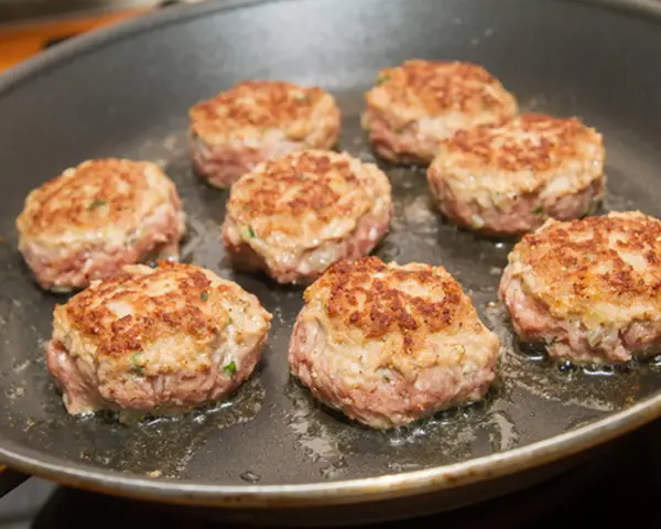 Sieben goldbraun gebratene Buletten in einer Pfanne. Ein klassisches Buletten Rezept, das duftet!