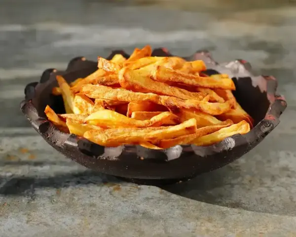Złociste, chrupiące frytki z airfryer w misie. Idealna przekąska, która zachwyci każdego.