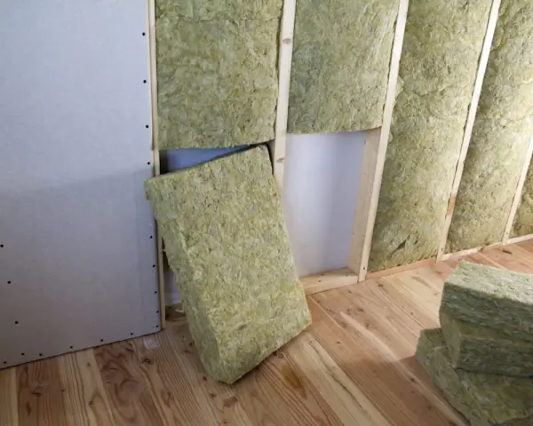 Installazione di materiali coibentanti in lana di roccia per l'isolamento termico di una parete in costruzione.