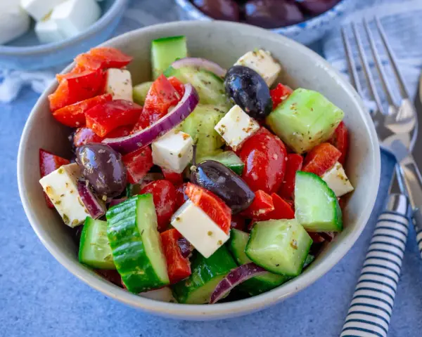 Frischer griechischer Salat mit Tomaten, Gurken, Paprika, roten Zwiebeln, Oliven und Feta – einer der 10 besten Salate für heiße Tage.