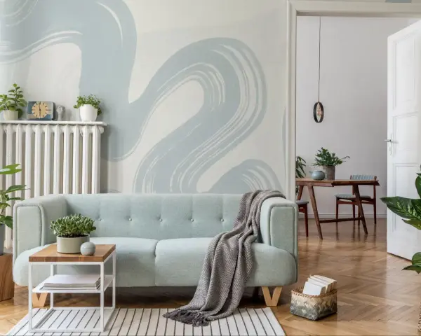 Miętowa kanapa i tapeta w stylu baby blue tworzą przytulną atmosferę.