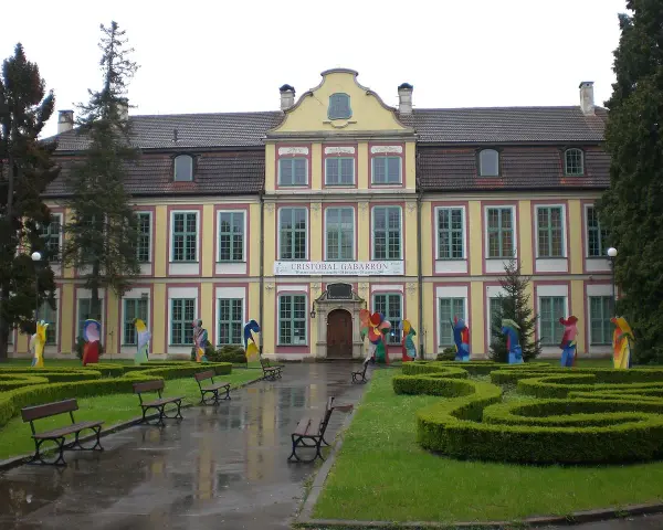 Pałac Opatów zaprasza na wystawę Cristobala Gabarrona. Kolorowe rzeźby zdobią dziedziniec przed zabytkowym budynkiem.