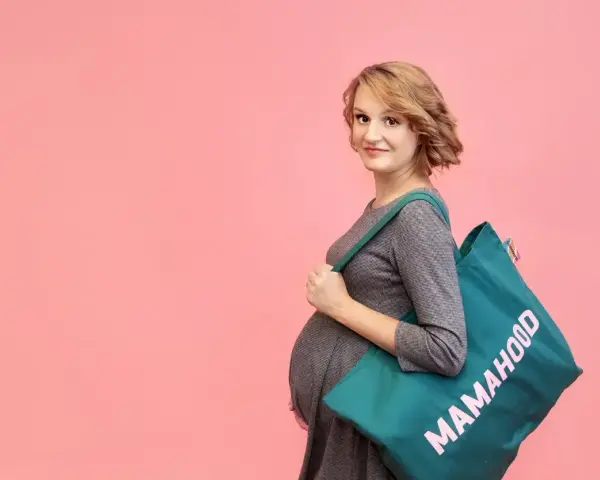 Przyszła mama z torbą "Mamahood" gotowa na wyprawkę do szpitala.