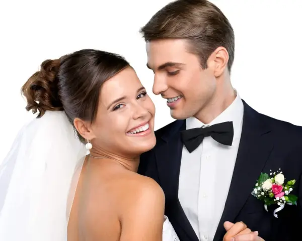Un jeune couple marié, souriant et complice. La mariée, voile sur la tête, et le marié, nœud papillon, se préparent pour la fête. Combien donner à un mariage cousin ?