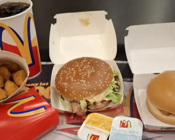 Zestaw McDonald's: burger, frytki, nuggetsy, napój i sosy.