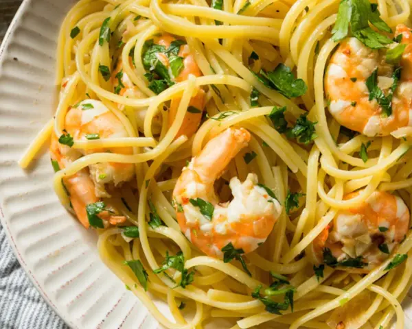 Un piatto invitante di pasta con gamberetti, condita con prezzemolo fresco e un filo d'olio.