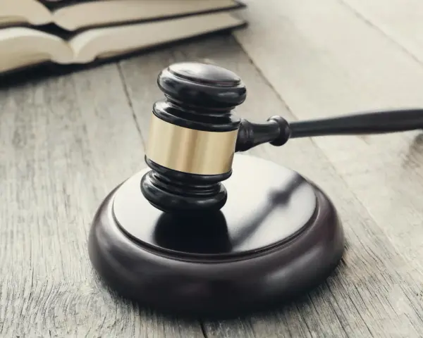 Młotek sędziowski i księgi na drewnianym stole. Sprawa o przedawnienie oszustwo może być trudna do udowodnienia.