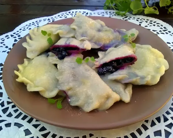 Pyszne pierogi z jagodami, delikatne i pełne owocowego smaku. Idealne na deser lub śniadanie.
