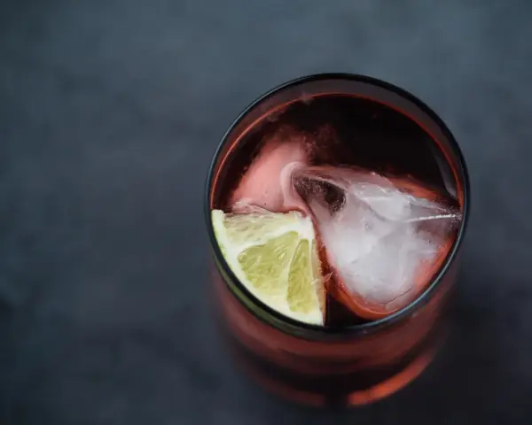Czerwony drink z lodem i limonką. Idealny do degustacji z brandy Kazbek Peak, odkryj nowe smaki!