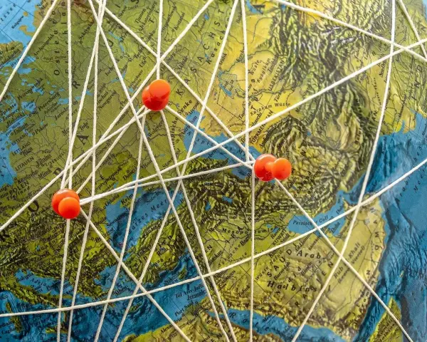 Marzenia o podróżach do Mozambiku? Mapa świata z zaznaczonymi trasami i pineskami symbolizuje plany na wakacje.