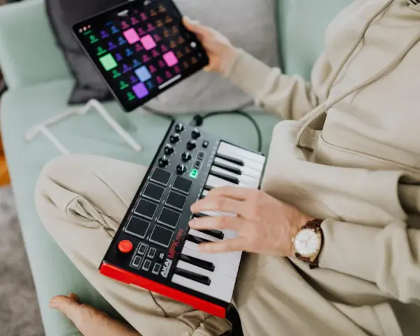 Osoba tworzy muzykę na kontrolerze midi usb. To świetny sposób na rozpoczęcie przygody z produkcją muzyczną.