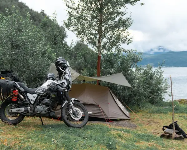 Motocyklem pod namiot nad jeziorem. Przygotowania do noclegu w dziczy.