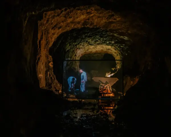 W jaskini wyświetlany jest film, na którym widać dwie postacie w pasiaste ubrania. Czy to osówka czy włodarz?