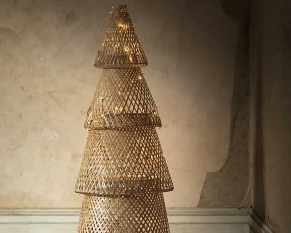 Un sapin de Noël en tissu à faire soi-même, fait de cônes tressés et illuminé de guirlandes lumineuses.