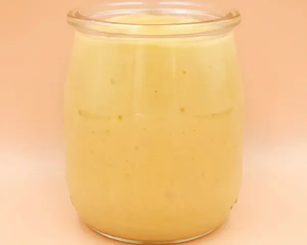 Gęsty, kremowy mango lassi w szklanym słoiku, gotowy do orzeźwiającego łyku.
