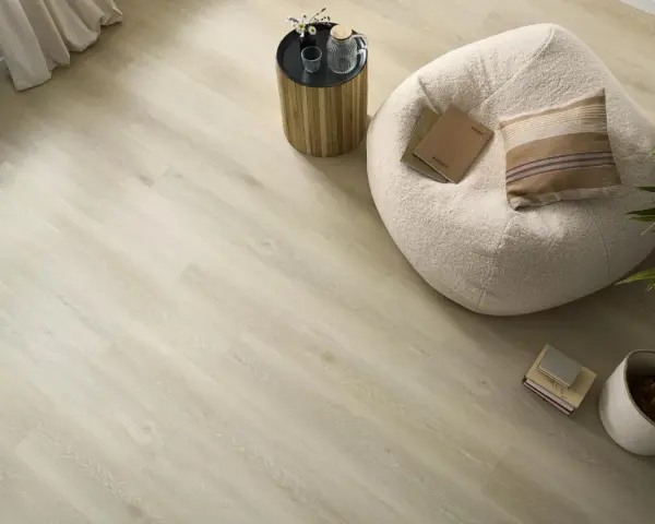 Jasna podłoga z paneli winylowych lub laminowanych, z pufą, stolikiem i rośliną. Idealna do nowoczesnego wnętrza.