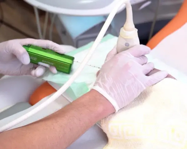 Arzt führt eine Brust-Biopsie mit einem speziellen Gerät durch. Hände in Handschuhen halten die Nadel und den Ultraschallkopf.