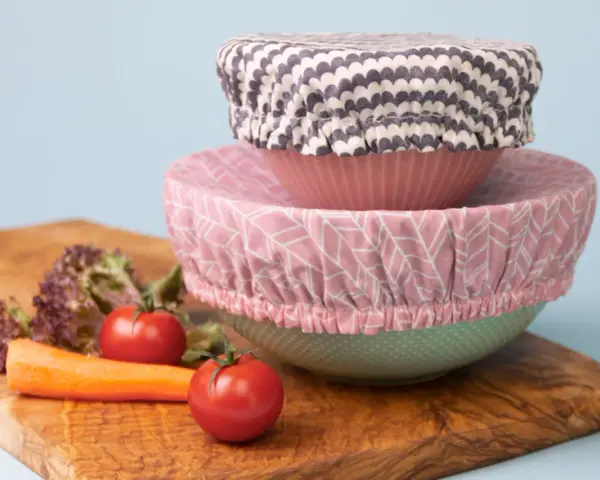 Trois couvre-plats en tissu avec des motifs différents, empilés sur des bols. Un tuto pour les réaliser soi-même.